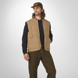 Danner - Danner Oxbow Primaloft Vest Khaki - Man wearing a tan vest over a black shirt and brown pants on a white background - Alternative View 1