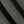 Load image into Gallery viewer, Close-up of a black and gray textured knit fabric with a diagonal shadow creating contrast.
