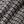 Load image into Gallery viewer, Close-up of a textured knit fabric with a black and off-white woven pattern, showing the detailed weave and soft folds.
