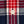 Load image into Gallery viewer, Close-up of a plaid fabric with red, navy, and white stripes, featuring a single cream-colored button.
