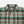 Load image into Gallery viewer, A close-up of a Dubbleware plaid button-down shirt in green, burgundy, and white, showing the collar, buttons, and chest pocket.
