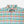 Load image into Gallery viewer, A close-up of a Doubleware plaid button-down shirt in a multicolor pattern of light blue, teal, orange, and yellow, featuring a pointed collar and two chest pockets.
