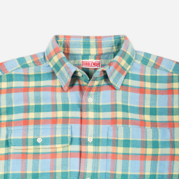 A close-up of a Doubleware plaid button-down shirt in a multicolor pattern of light blue, teal, orange, and yellow, featuring a pointed collar and two chest pockets.