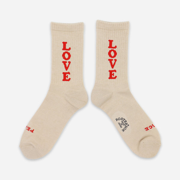 A pair of cream-colored crew socks with the word 'LOVE' printed vertically in red on each sock, displayed against a light gray background.