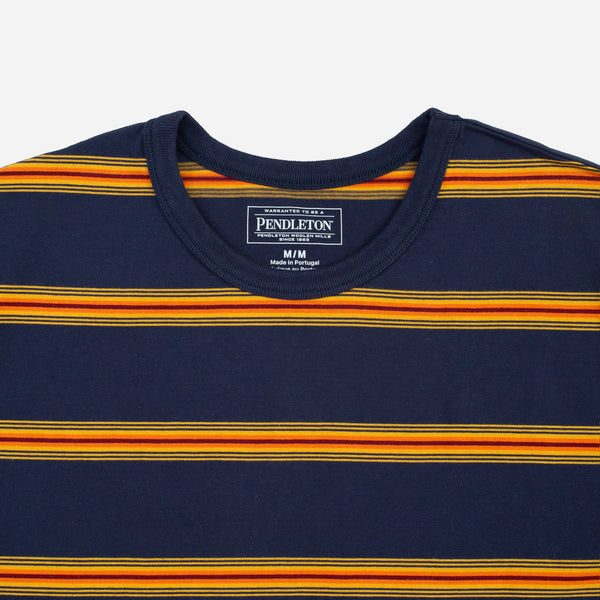 Close-up of a Pendleton crewneck t-shirt featuring horizontal stripes in navy blue, orange, and yellow, with the brand label visible inside the collar.