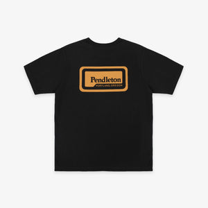 Pendleton - Patch T-Shirt - Dark Grey - A black short-sleeve t-shirt with a tan rectangular graphic on the chest that reads 'Pendleton PORTLAND OREGON'. The t-shirt is displayed flat against a light gray background. - Alternative View 1