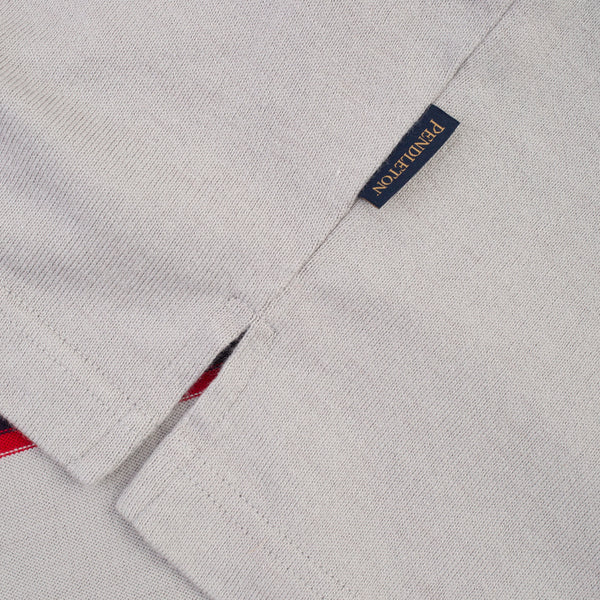 Close-up of a light gray woven fabric garment with a small navy brand tag reading PONDUTTON in gold lettering.