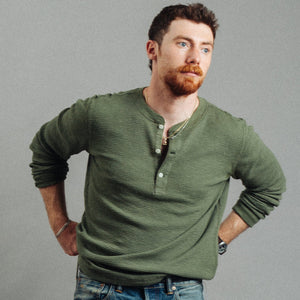 Double RL By Ralph Lauren - Garment-Dyed Waffle Henley T-Shirt - Tree Green - A man with a red beard wearing an olive green ribbed long-sleeve henley shirt and blue jeans, posing with hands on hips against a solid gray background. - Alternative View 1